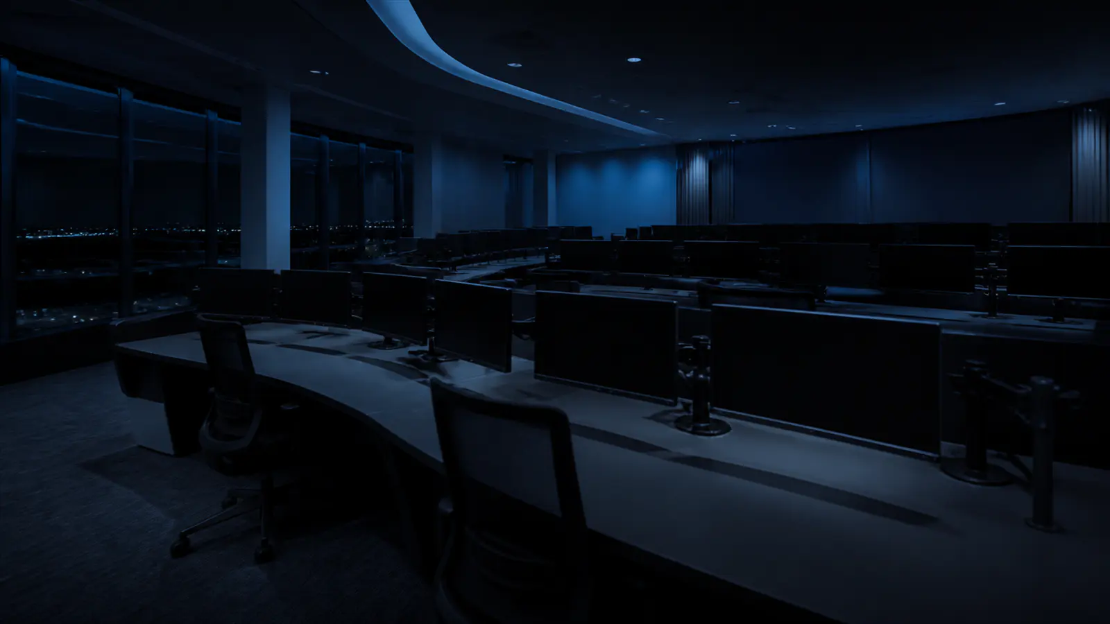 An unoccupied operations room, screens dark.